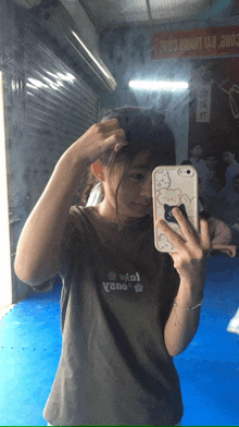a girl is taking a picture of herself in a mirror wearing a t-shirt that says viet vepa