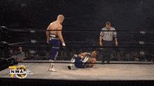 two wrestlers in a ring with a nwa logo
