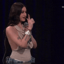 a woman is holding a microphone in her hand and pointing