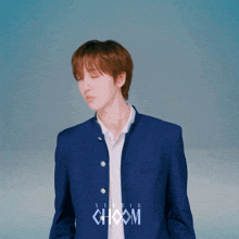 a young man wearing a blue jacket with the word choom on it