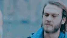 a man with a beard and long hair is making a funny face .