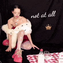 a woman sitting in front of a black curtain that says not at all