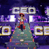 a woman is standing on top of a green staircase in front of a large screen that says ceo on it .