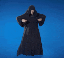 a man in a black robe with a hood is dancing