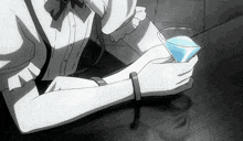 a person is holding a glass of blue liquid in their hand .