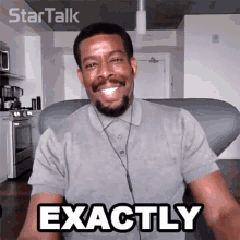 a man with a beard and ear buds is smiling and says exactly
