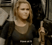 a woman is holding a stick with the words have at it written on it
