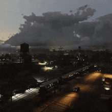 an aerial view of a city at night with a water tower in the distance