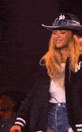a woman wearing a cowboy hat and a jacket with ny on it