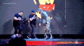 a man standing on a stage in front of a large screen that says #wwechamber