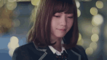 a young woman in a school uniform is crying while looking down .