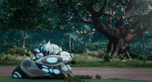a robot is laying on the ground in front of a large tree