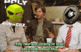 two men sitting at a table with a sign that says gunnerz