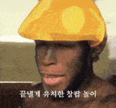 a man wearing a yellow hat with korean writing on the bottom