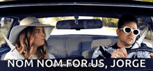 a man and a woman are sitting in a car with the words nom nom for us jorge written above them