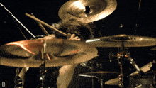 a man playing drums with a cymbal that has the letter d on it