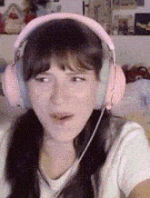 a woman wearing pink headphones with a microphone on her head .