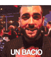 a man in a suit says " un bacio " in front of a crowd of people