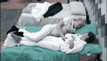 two people are laying on a bed with their legs crossed .