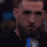 a man with a beard is holding a microphone in front of him .