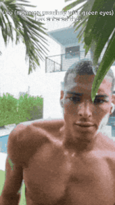 a man without a shirt is standing under a palm tree with the caption leo months good boy with green eyes