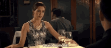 a woman is sitting at a table in a restaurant talking to a man and says `` that 's bullshit '' .