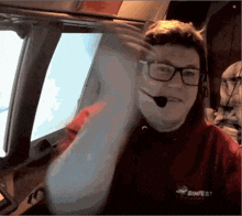 a man with glasses and a simfest shirt on
