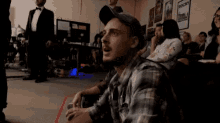 a man in a plaid shirt is sitting in front of a poster that says rocky on it