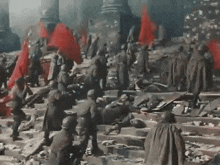 a group of soldiers are standing in front of a building with red flags in the air .