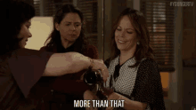 a woman is pouring wine into another woman 's glass while another woman says more than that .
