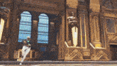 a woman stands in front of a building with statues