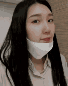 a woman wearing a white mask on her face .