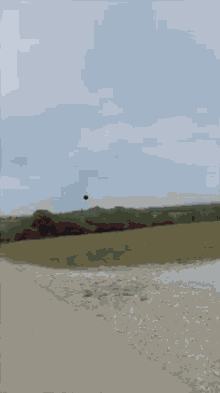 a black ball is flying through a cloudy sky