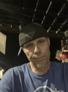 a man wearing a blue shirt and a black hat is smiling for the camera