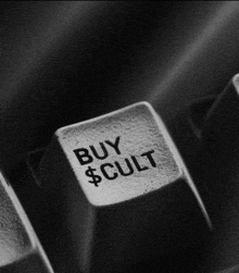 a black and white photo of a keyboard key that says buy $ cult