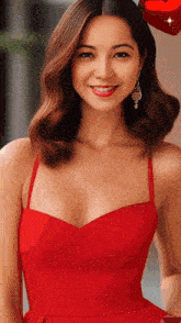 a woman in a red dress is smiling with a red heart in the background