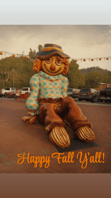 a statue of a scarecrow with the words happy fall y'all