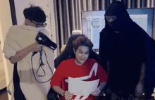 a man holding a hair dryer next to another man
