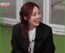 a woman with red hair is wearing a black jacket and a white t-shirt with the word life on it