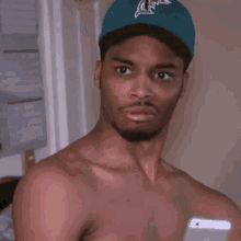 a man with a beard wearing a blue hat is making a funny face .