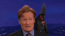 a man with a parrot on his shoulder has the word meh written on the bottom
