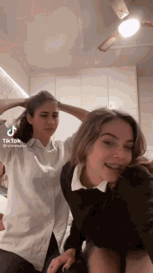 two women are standing next to each other and one has braces on her teeth