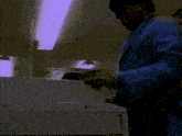 a man in a blue lab coat is standing in front of a printer that says hp on it
