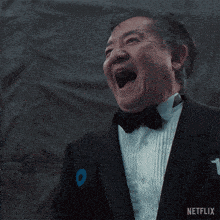 a man in a tuxedo with a netflix logo on the bottom