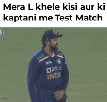 a man in a byju 's india jersey is standing on a field