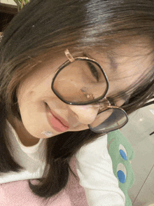 a girl wearing glasses has a sticker on her face