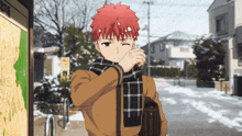 a man wearing a scarf is standing in front of a sign that says ' tokyo ' on it