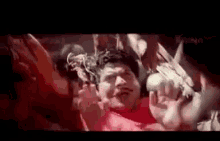 a group of people are holding a man 's head in a crowd .