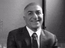 a man in a suit and tie is smiling in a black and white photo with the hashtag @ingitbot