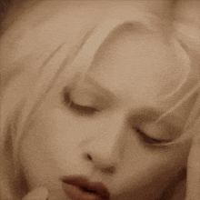 a close up of a woman 's face with her hand covering it